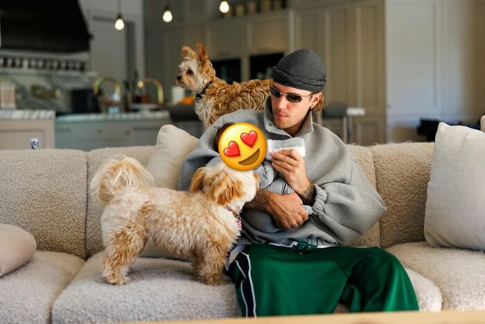 Justin Bieber sitting on couch with two dogs, opening up about marriage and mental struggles in new album.