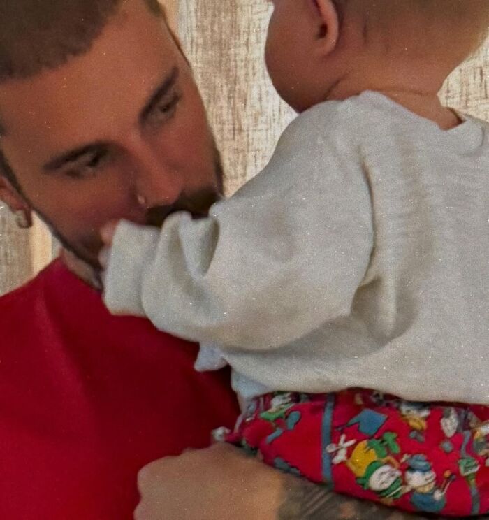 Justin Bieber holding a baby, reflecting on marriage and mental struggles featured in new album SWAG.