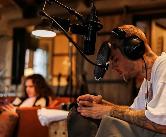 Justin Bieber recording in studio with headphones and mic, reflecting on marriage and mental struggles for new album.