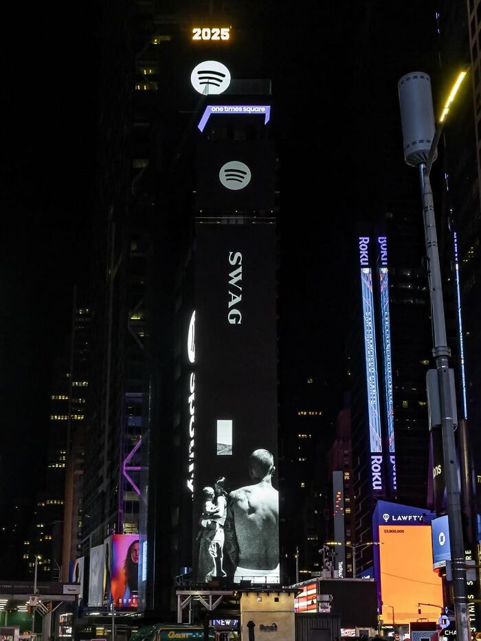 Times Square digital billboard at night displaying promotion for Justin Bieber&rsquo;s new album SWAG about marriage and mental struggles.