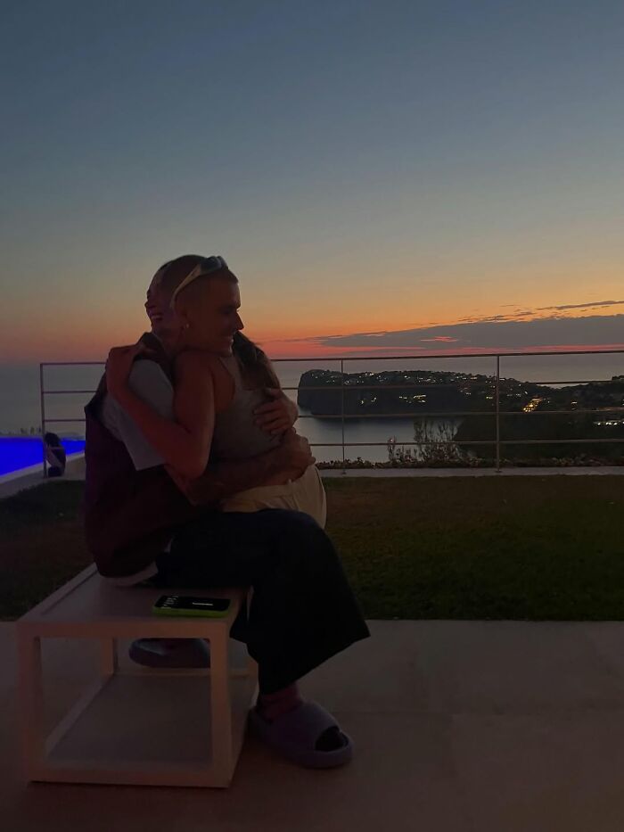 Justin Bieber and a woman hugging outdoors at sunset, reflecting on marriage and mental struggles in new album.