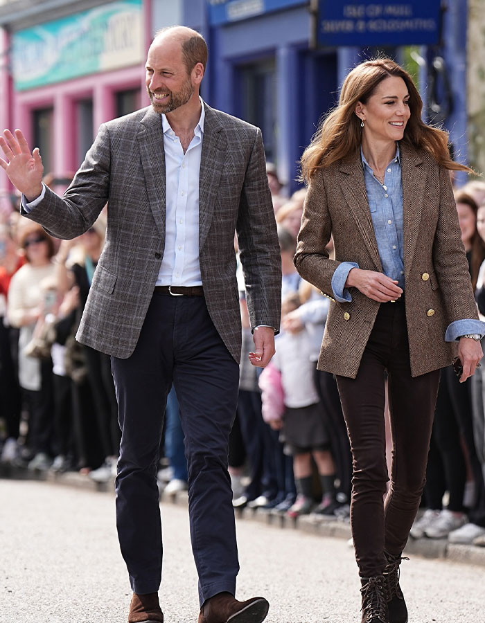 Prince William and Kate walking outdoors during public event, contrasting with news of Prince Harry snubbed by King Charles. Prince William and Kate walking outdoors during public event, contrasting with news of Prince Harry snubbed by King Charles.