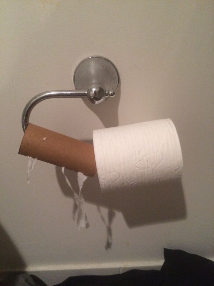 Toilet paper roll incorrectly placed with empty cardboard next to a new roll, illustrating bad roommate habits from Reddit tales.