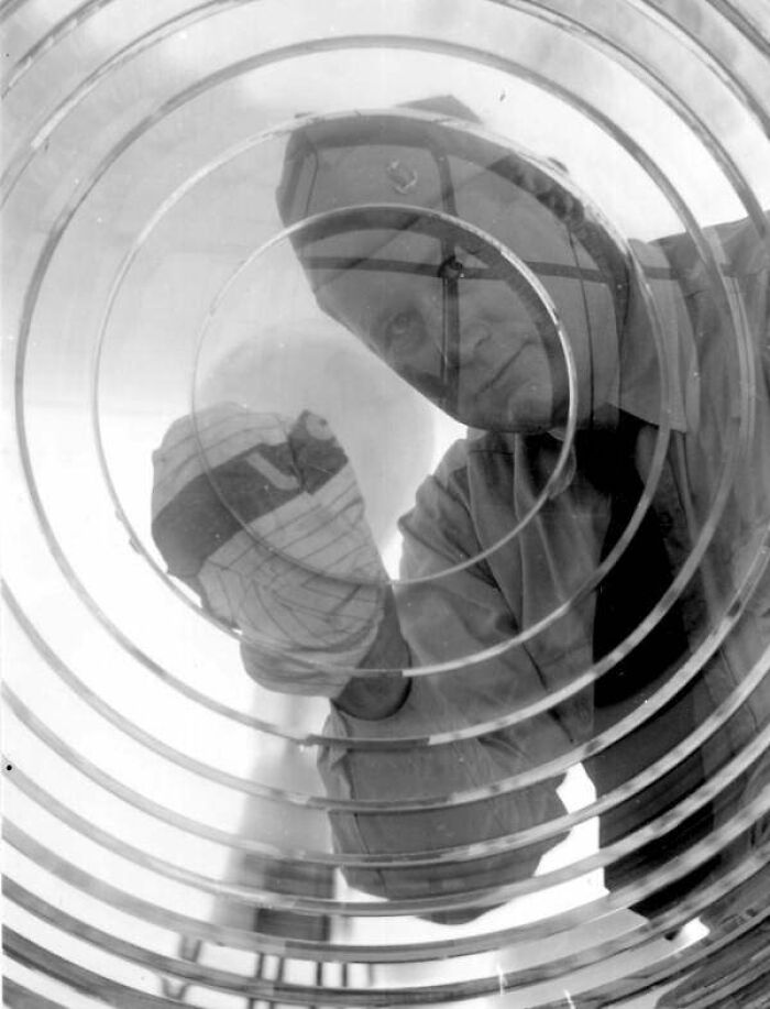 Medical professional examining an X-ray through concentric circular glass in rare and interesting historical photograph.