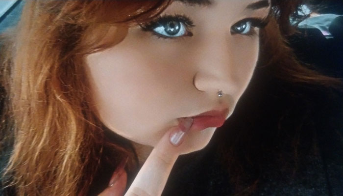 Close-up of a teen with red hair and piercing, symbolizing the danger of lightning strikes inside the house while using a phone. Close-up of a teen with red hair and piercing, symbolizing the danger of lightning strikes inside the house while using a phone.