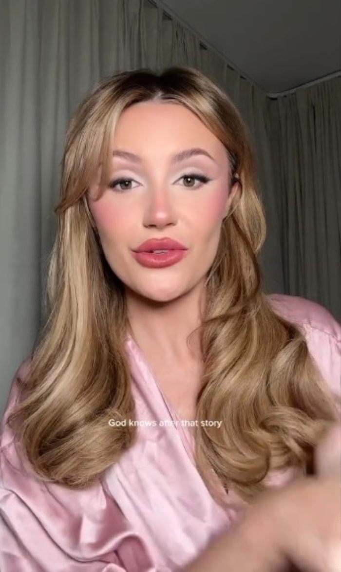 Woman with styled blonde hair wearing a pink silk robe, sharing her experience with plastic surgery recovery mistakes. Woman with styled blonde hair wearing a pink silk robe, sharing her experience with plastic surgery recovery mistakes.