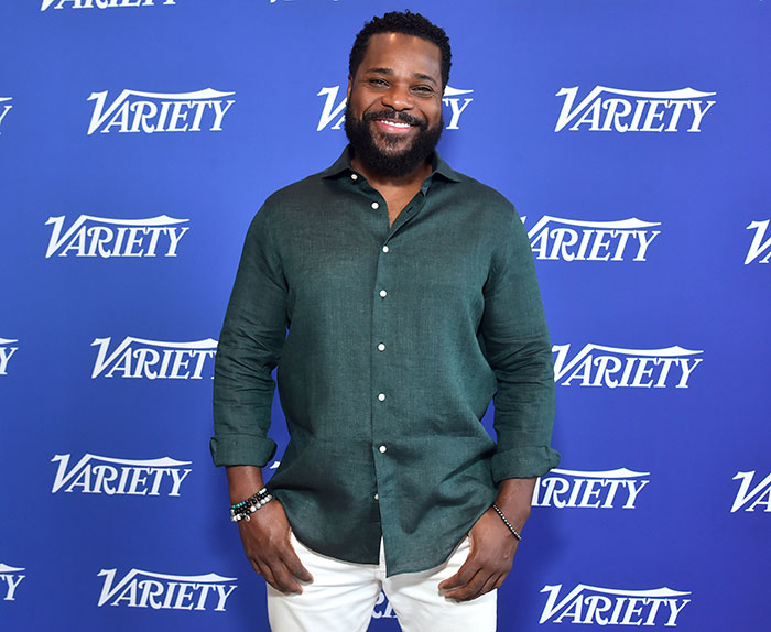 Man in a green button-up shirt and white pants smiling at Variety event, connected to second victim tragic accident SEO keyword. - 1