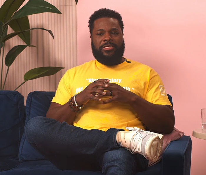 Man sitting on blue couch wearing yellow shirt and white sneakers, discussing second victim revealed in tragic accident news.