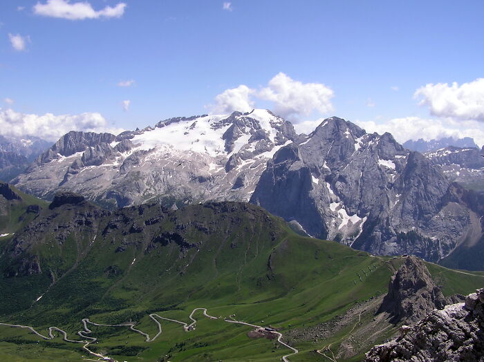 Mountain landscape with snow-capped peaks and winding roads illustrating natural disasters in the last century.