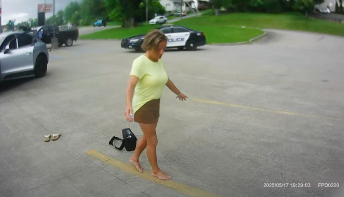 Olympic Gold Medalist Mary Lou Retton barefoot outside near police cars during sobriety test at arrest site.