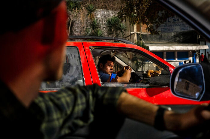 Two men in cars captured in an honest street moment showing the beauty of everyday life.
