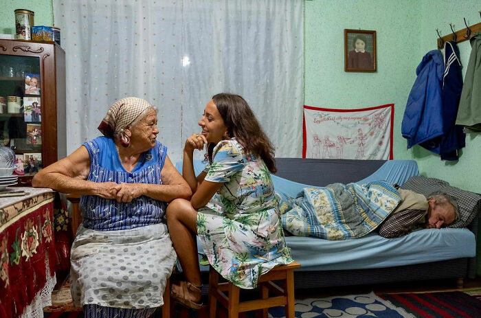 Elderly woman and young woman sharing an honest street moment, capturing the beauty of everyday life indoors.