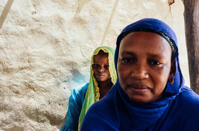 Two women in vibrant traditional clothing captured in an honest street moment showing the beauty of everyday life.