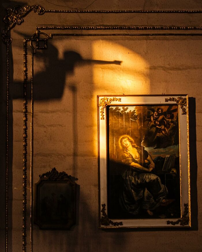 Framed painting illuminated by warm light, showcasing honest street moments and the beauty of everyday life captured by a photographer.