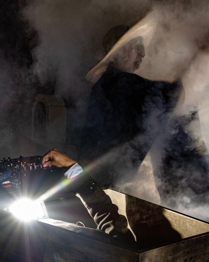 A photographer captures honest street moments with dramatic lighting and smoke, revealing the beauty of everyday life.