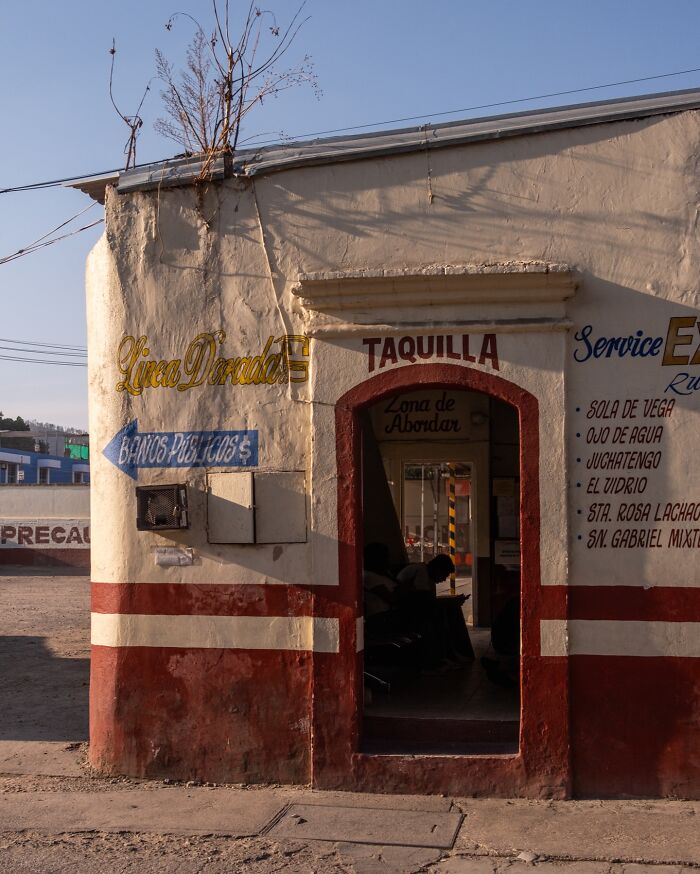 Street scene with people inside a ticket booth, showcasing honest street moments and the beauty of everyday life.