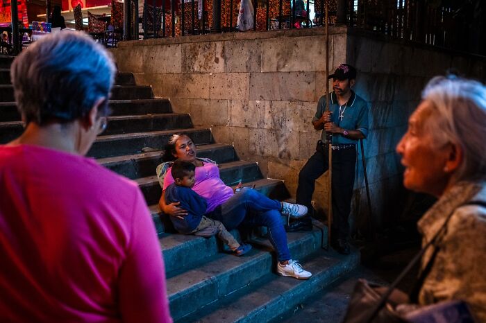 A photographer captures honest street moments showing the beauty of everyday life with people interacting on stone steps.
