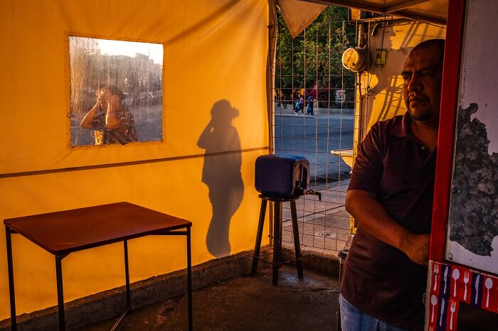 Street moments showing a man’s shadow on a yellow wall and a reflective window in an everyday urban setting.