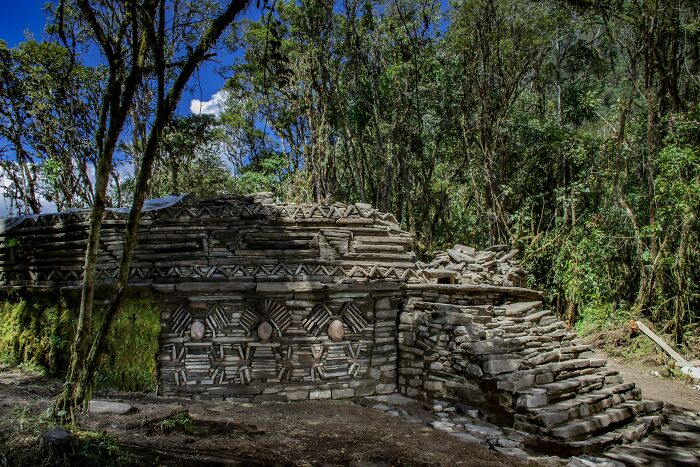Ancient stone structures linked to mysterious civilization uncovered by archaeologists in dense forest under clear blue sky. - 10