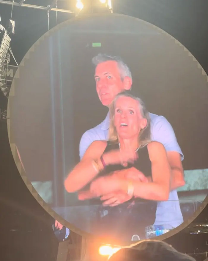 Couple on Coldplay kiss cam displayed on large screen, capturing staff reaction to toxic CEO drama at event.