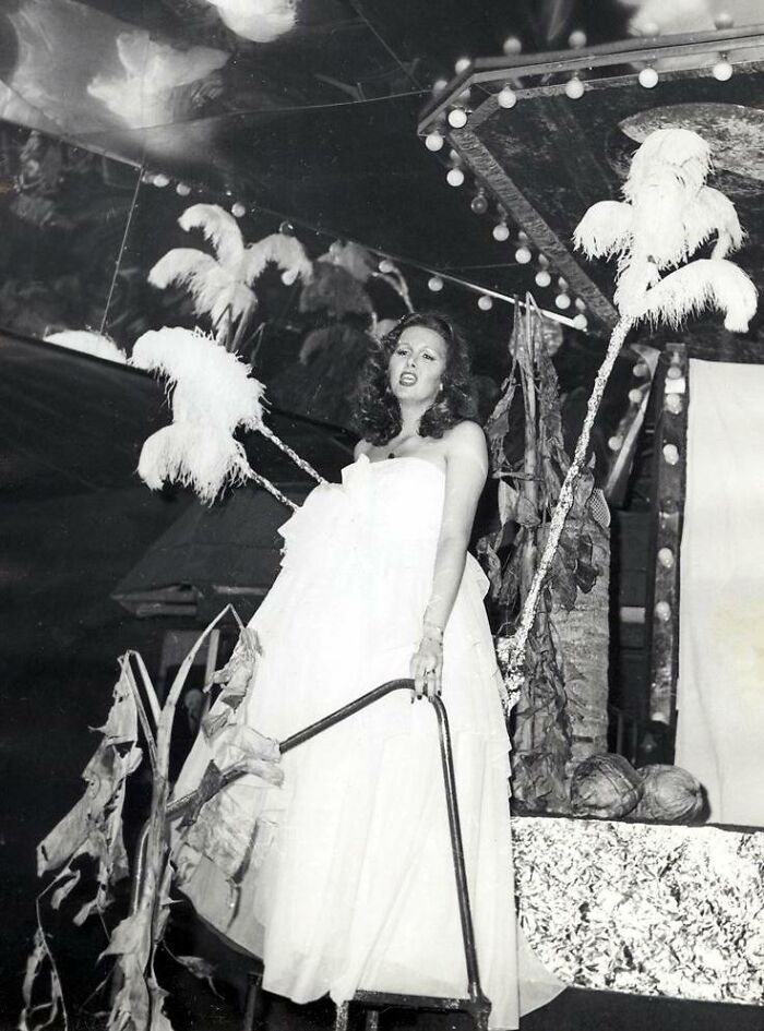 Woman in Florida wearing a white gown with feathered decorations, breaking barriers in the 1970s vintage photo.
