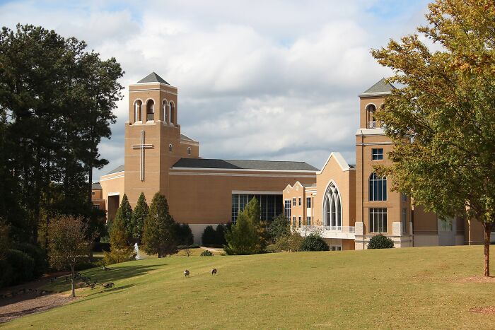 Modern church building with a cross on the tower, surrounded by trees and green lawn, showcasing best places to live in the USA.