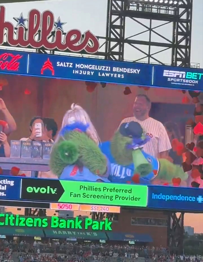 Baseball mascot hilariously mocking disgraced CEO during kiss cam moment at Phillies game in Citizens Bank Park.