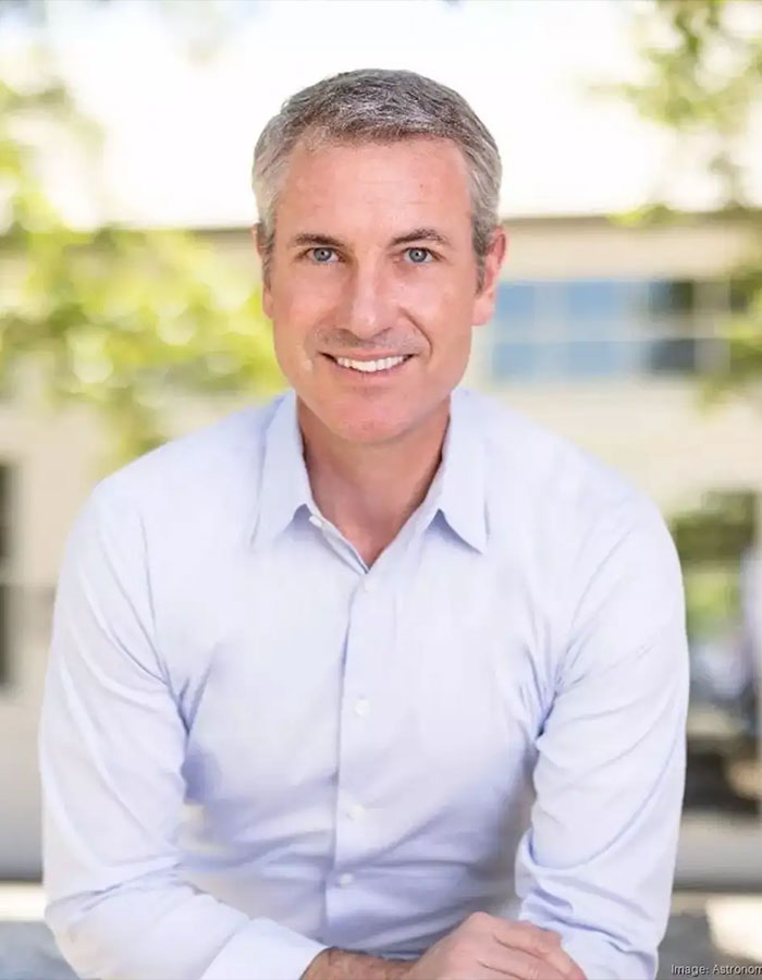 Smiling man in a light blue shirt, representing a disgraced CEO involved in a kiss cam scandal.