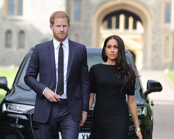 Meghan Markle and Prince Harry walking outside in formal attire, highlighting Meghan Markle and Prince Harry in the spotlight.