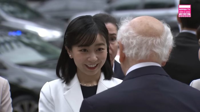 Japanese Princess Kako smiling and interacting with elderly man outdoors, viral moment captured in casual setting.