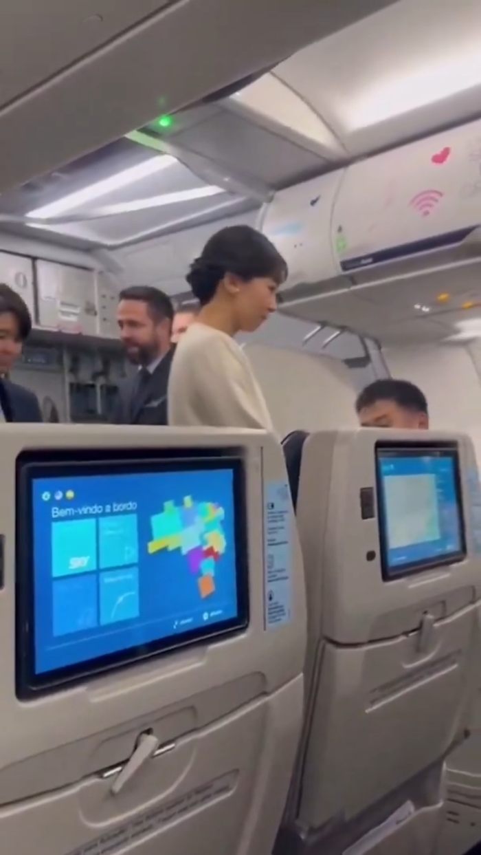 Japanese Princess Kako seated in economy class cabin interacting with passengers during a flight.