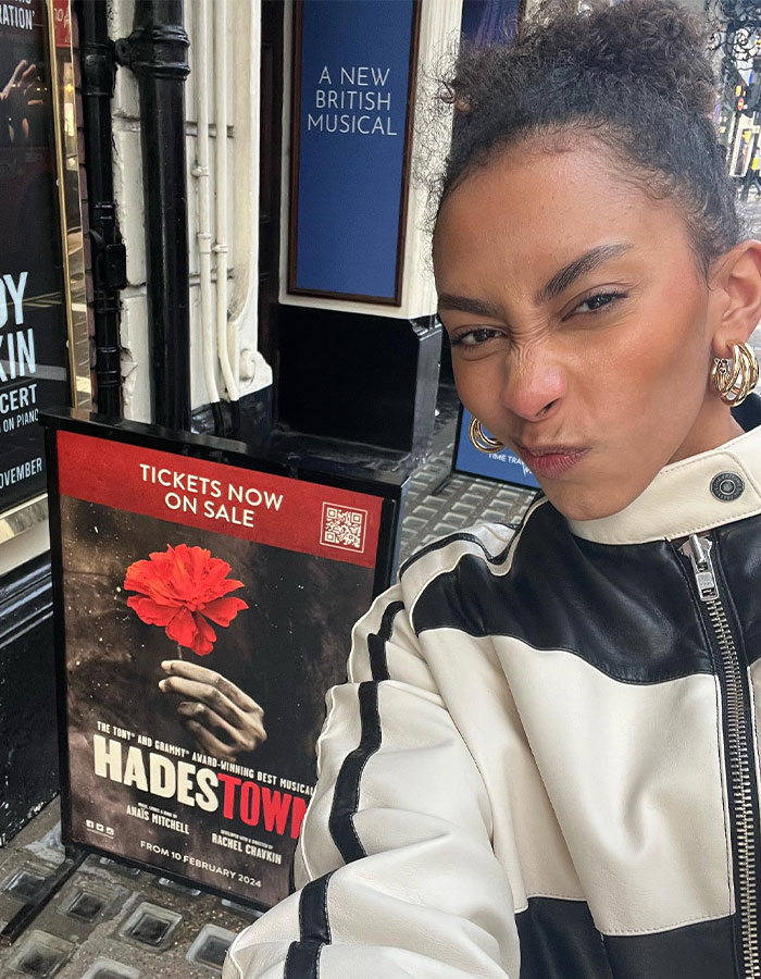 Person taking a selfie near a poster outside theater, related to Rachel Zegler suddenly exiting Evita mid-show. Person taking a selfie near a poster outside theater, related to Rachel Zegler suddenly exiting Evita mid-show.