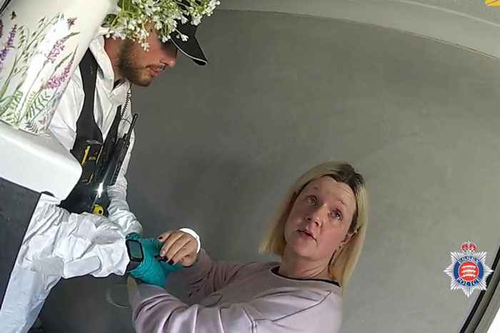 Woman held by police officer inside a room in a documentary about woman who lived with deceased parents for 4 years - 8