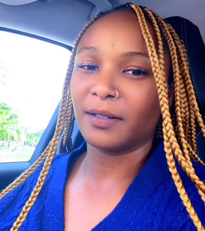 A woman with braided hair and a nose ring inside a car, related to official sparks outrage flood-stricken camp Mystic controversy.