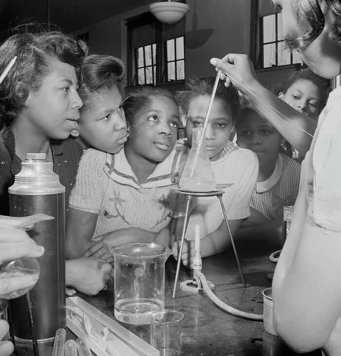 African American girls engaged in a science experiment in a school laboratory during World War II.