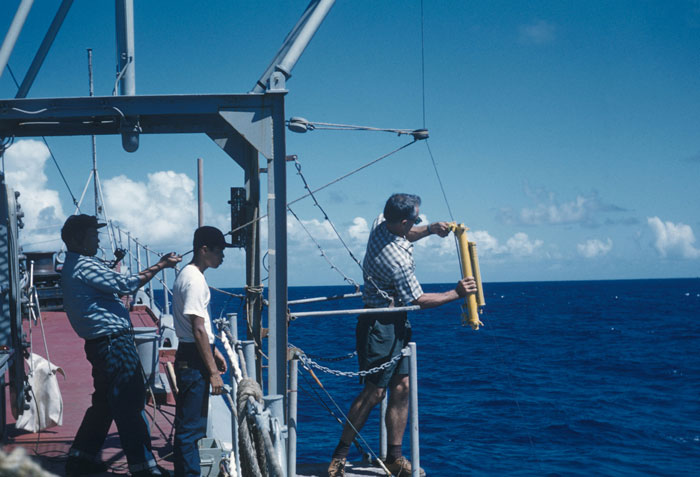 Scientists on research vessel preparing equipment to drop cow carcass 1629 meters deep into sea for marine study.