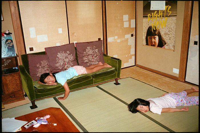 Two children resting in a traditional Japanese room with tatami mats, showcasing daily life in Japan by Shin Noguchi.