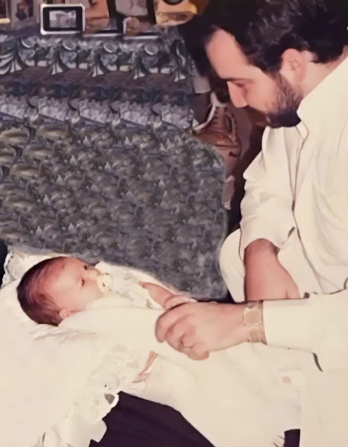 Man in white shirt looking tenderly at a baby lying down, representing the sleeping prince of Saudi Arabia. Man in white shirt looking tenderly at a baby lying down, representing the sleeping prince of Saudi Arabia.