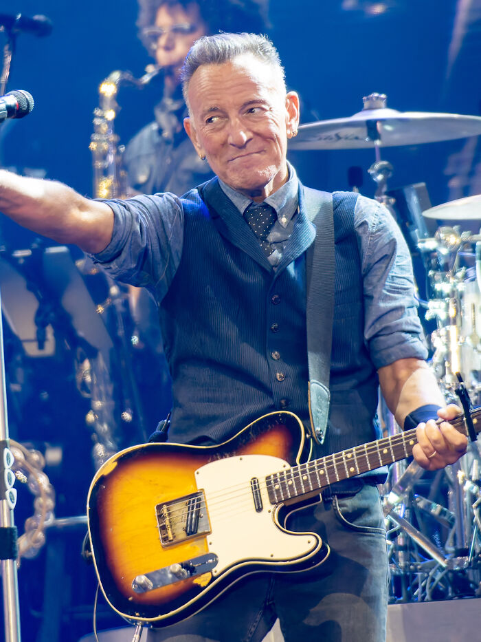 Musician performing on stage with guitar, representing celebrities that were misunderstood in their time.