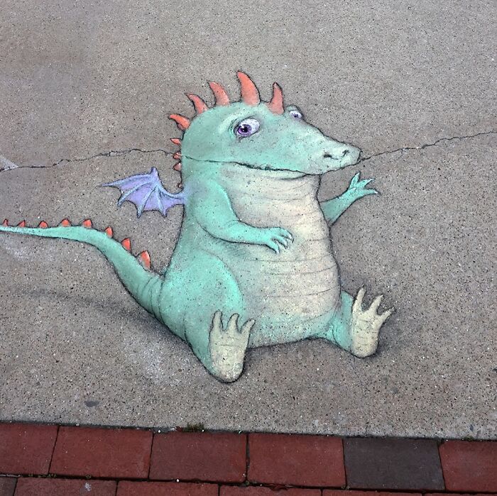 Chalk drawing of a whimsical dragon on sidewalk by David Zinn, showcasing magical world created with chalk art.