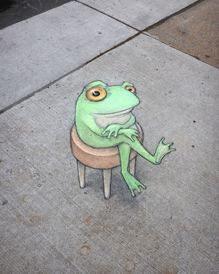 Chalk art of a relaxed green frog sitting on a stool, showcasing David Zinn’s sidewalk magical worlds artwork.