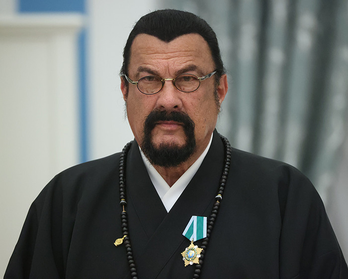 Steven Seagal con gafas y medallas, representando una de las celebridades que arruinaron su reputación pública.