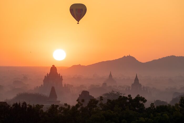 Hot air balloon over ancient temples at sunrise, capturing the soul of Asia in a stunning and serene landscape photo.