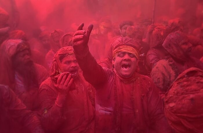 A vibrant scene capturing the soul of Asia with people covered in red powder during a lively cultural festival.