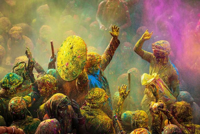 People celebrating Holi festival throwing vibrant colored powder, capturing the spirit and soul of Asia through stunning photography.