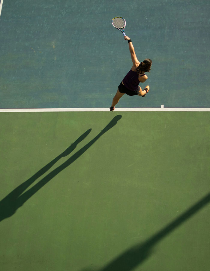 Tennis pro in action hitting a serve on court, highlighting the sports career of a young female athlete. Tennis pro in action hitting a serve on court, highlighting the sports career of a young female athlete.