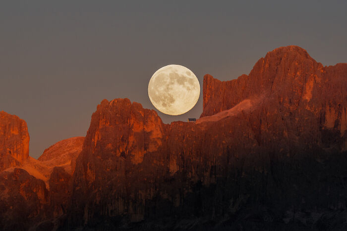 Full moon rising over rugged red rock mountains at dusk, one of the most breathtaking space photos from 2025 astronomy shortlist.