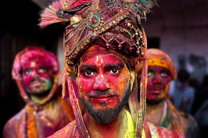 Vibrant street portrait of a man covered in colorful powder, showcasing powerful street photos capturing the soul of India.