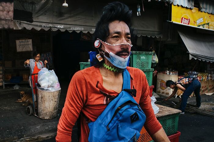 Man wearing creative face mask in a busy street market, captured in powerful street photos of India by Rohit Vohra.