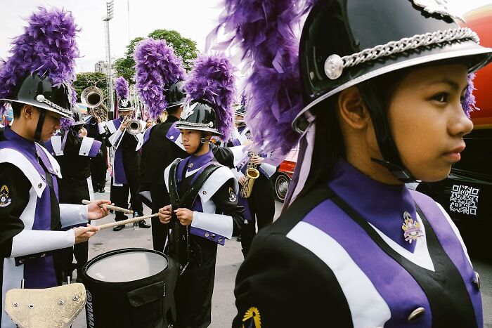 Young Indian marching band members in vibrant purple uniforms preparing to perform in a powerful street photo capturing the soul of India.